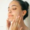 Woman applying daily skincare in warm natural morning light representing gentle skin barrier support and realistic routines.